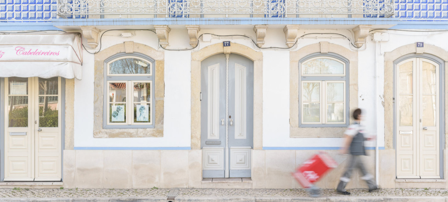 Carteiro na rua, com a sua mala de correio.