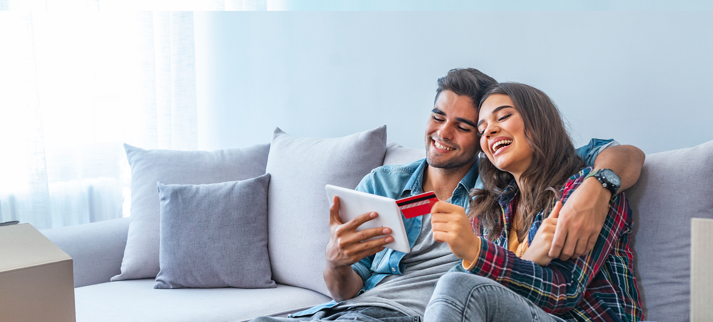 Um casal a fazer uma compra online em sua casa, registando a sua morada virtual.