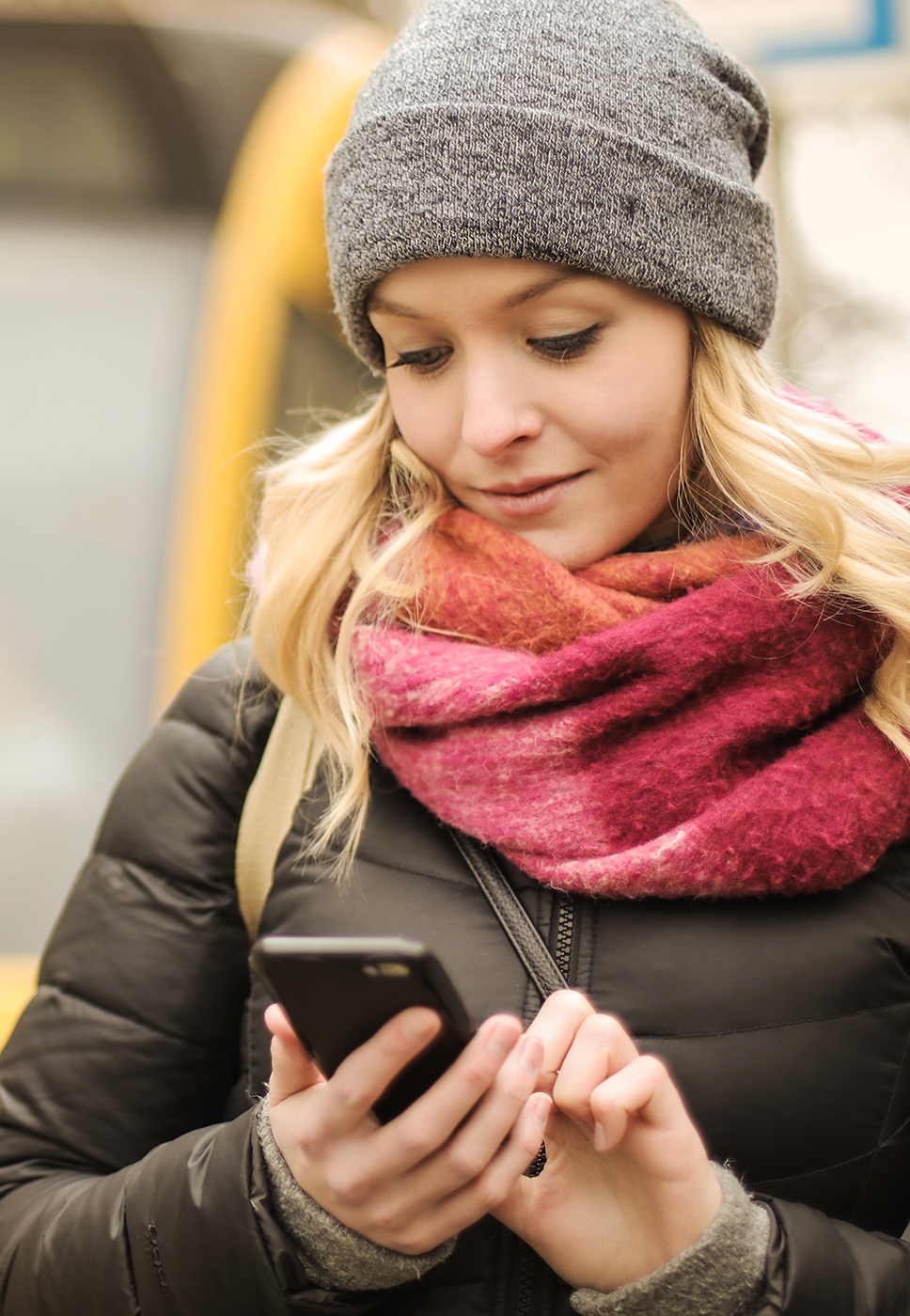 Senhora pesquisa no seu telemóvel onde pode fazer o carregamento do seu passe.