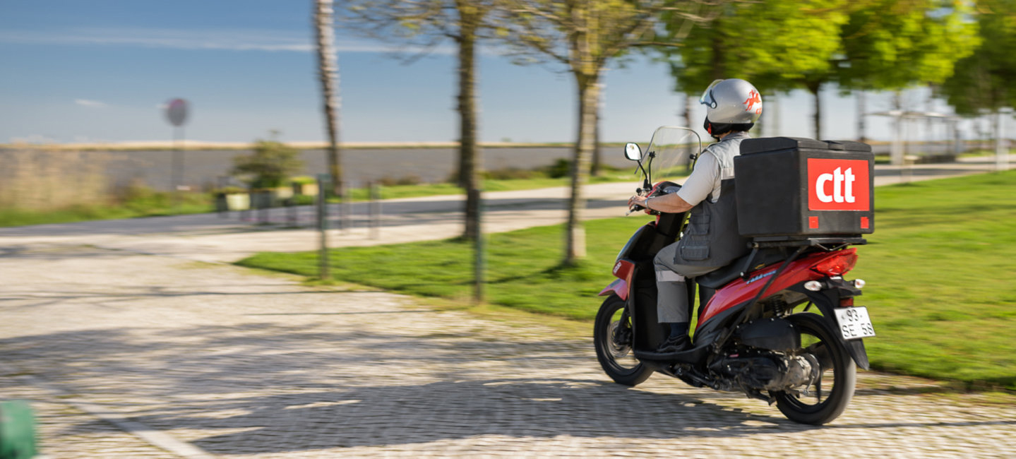 Carteiro a andar de mota.