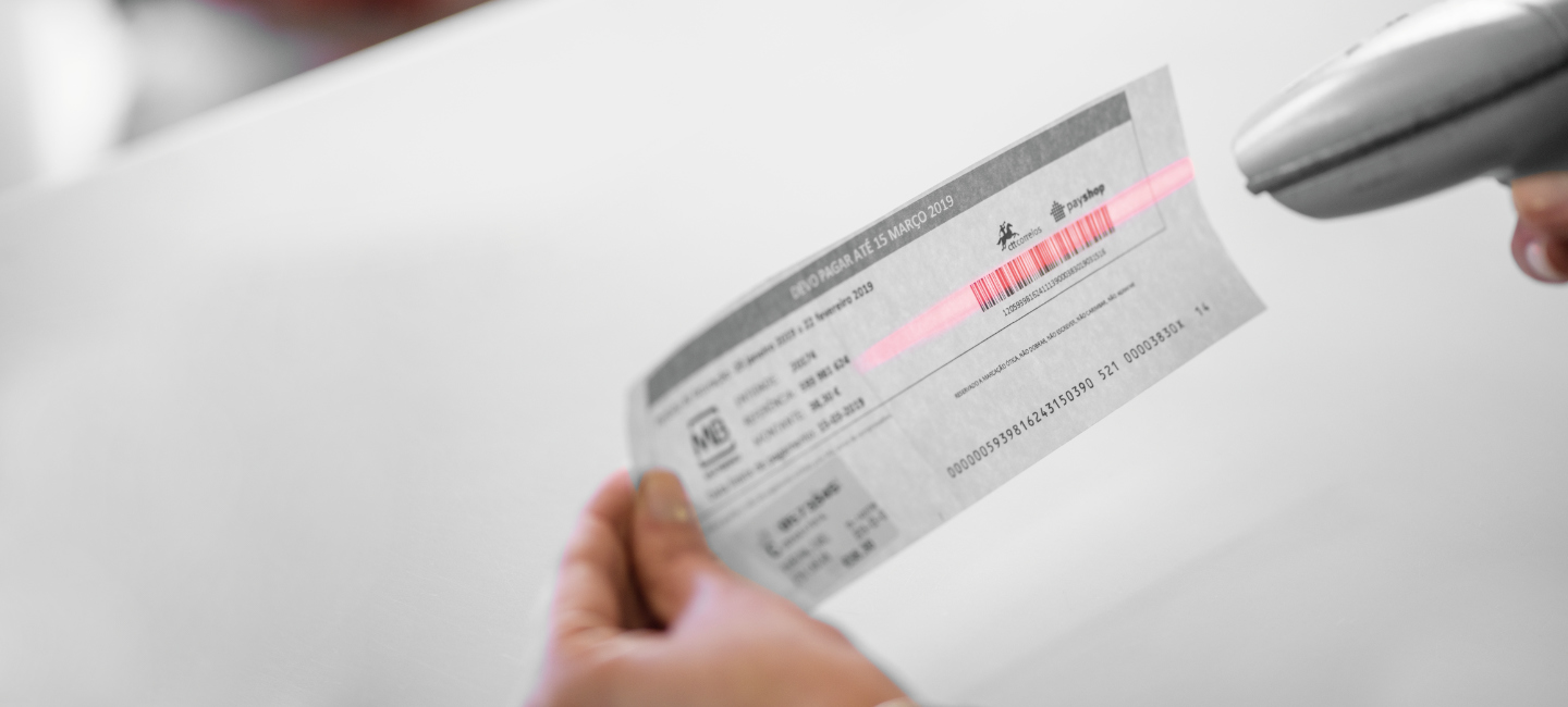 Pessoa a pistolar um código de barras para efetuar um pagamento