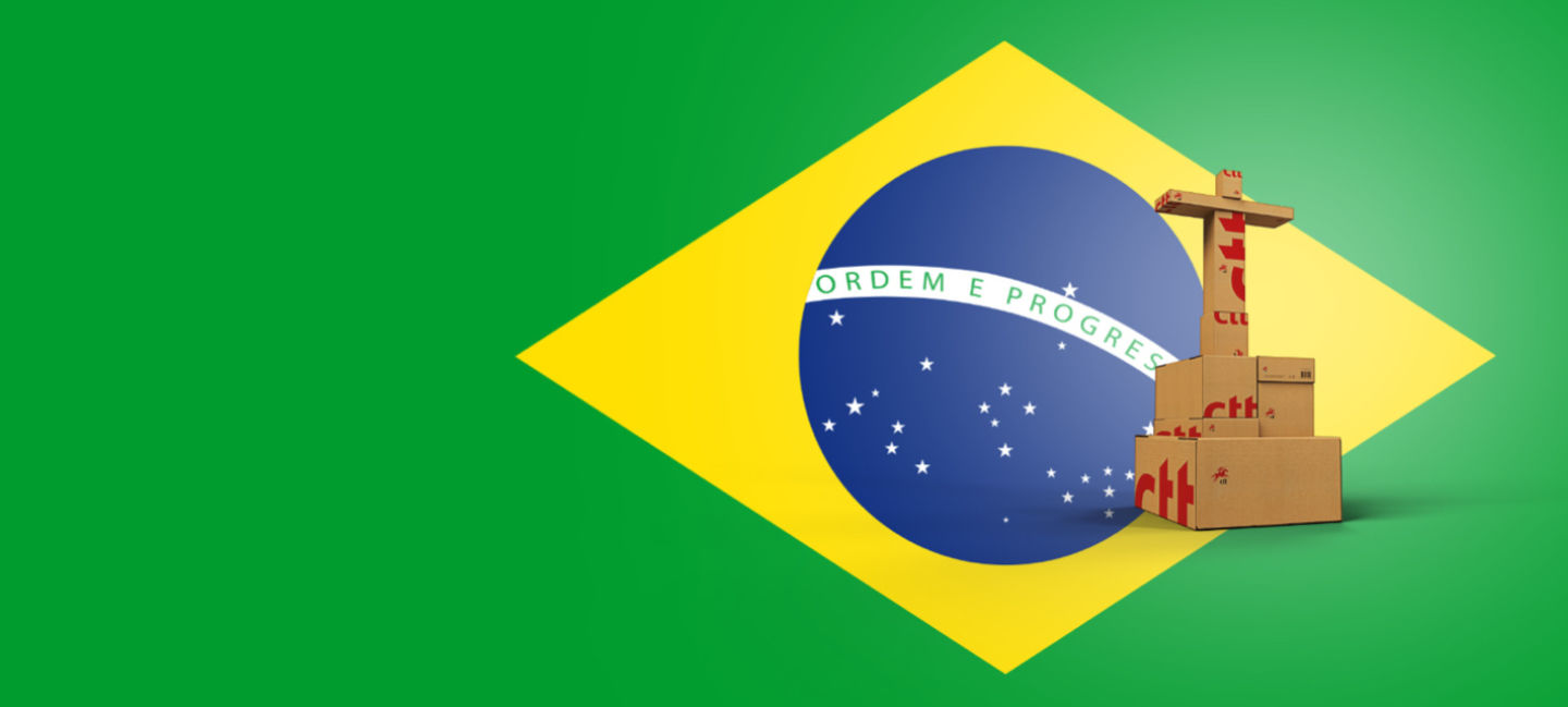 Caixas empilhadas a imitar a forma do Cristo Rei, no fundo está a bandeira do Brasil.