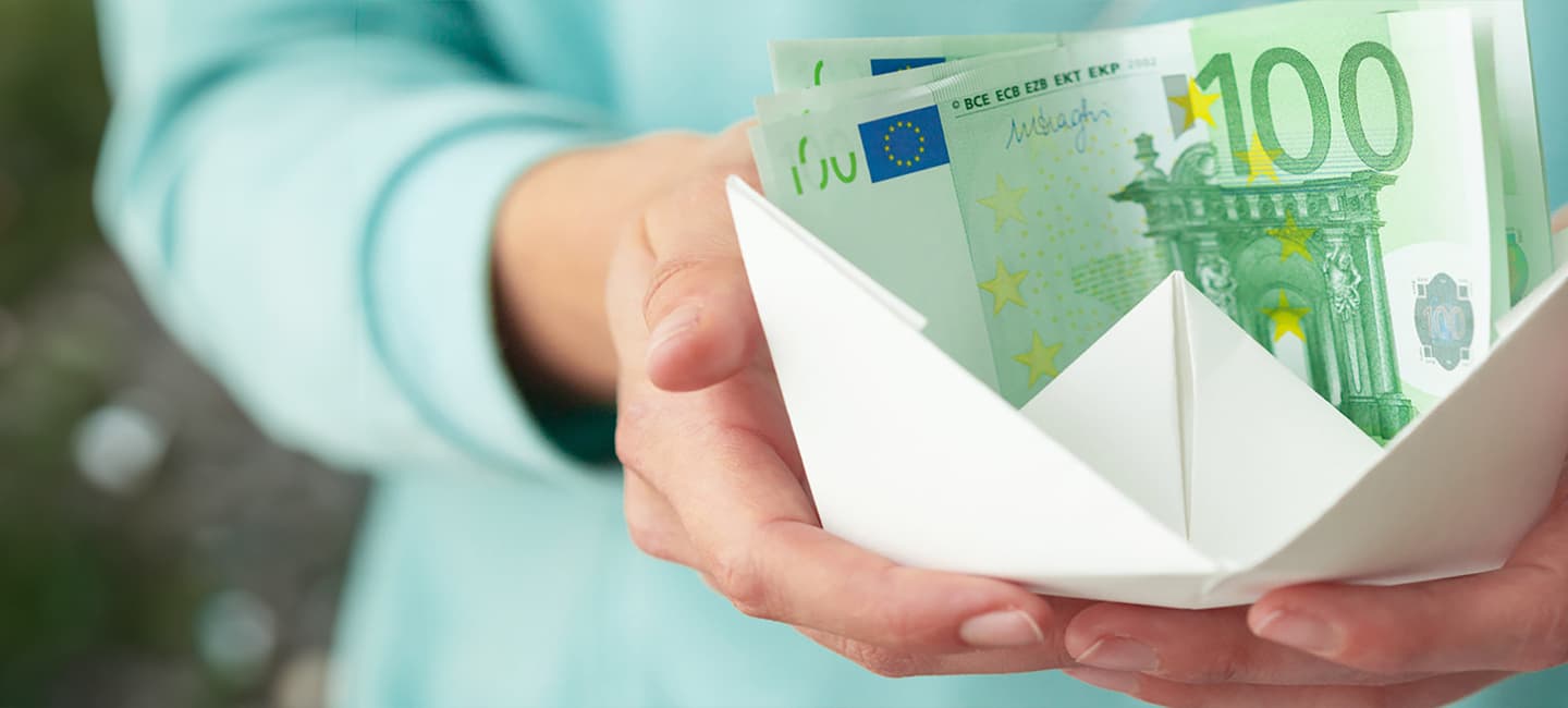 Mãos a entregar nota de 100