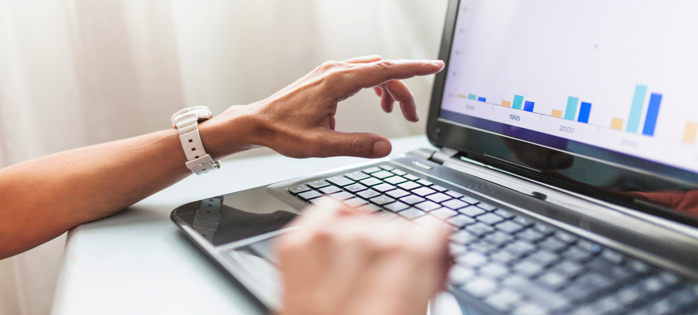 Senhor analisa tabelas através de um computador.