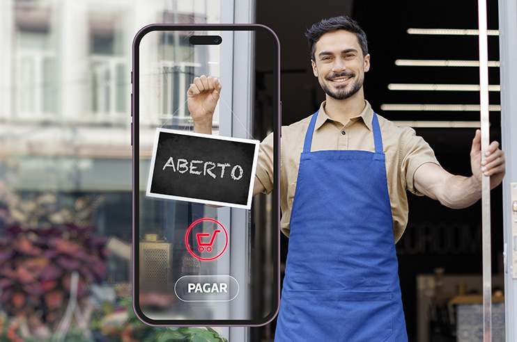 Lojista a abrir o estabelecimento comercial e com um telemóvel a informar que é possível pagar digitalmente