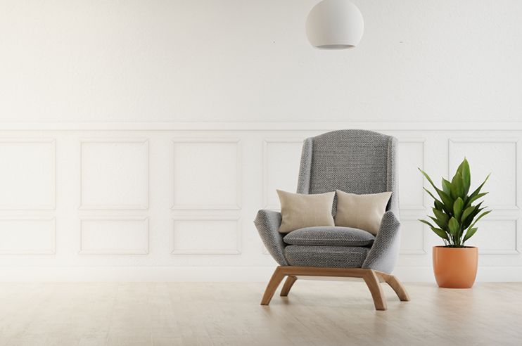 Sala com cadeirão e uma planta.